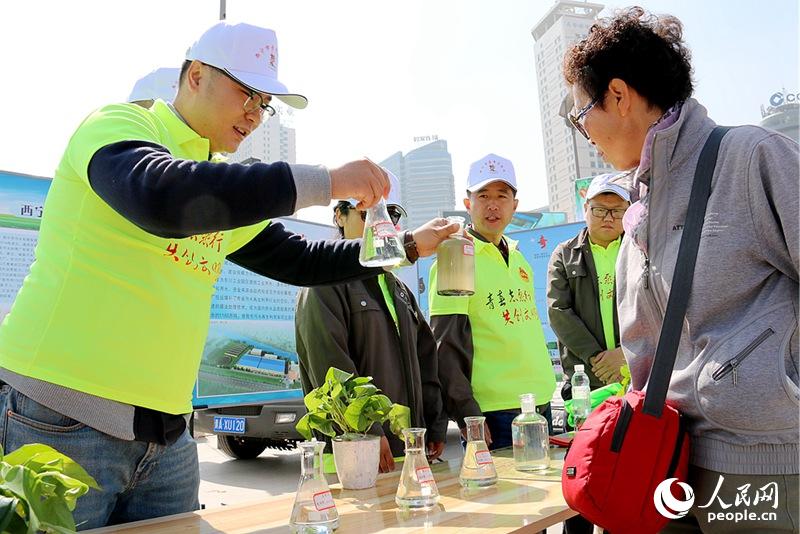 青年志愿者为市民宣传保护水环境常识。